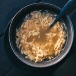 Miseczka gorącego bulionu z makaronem ramen na ciemnym blacie