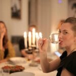 Przyjaciele piją wino przy nastrojowej, kameralnej kolacji w domu