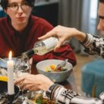 Przyjaciele przy domowej kolacji z winem i azjatyckimi daniami