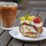 Rolada biszkoptowa z owocami i kawa mrożona na drewnianym stole