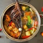 Gorący bulion z makaronem, krewetkami i warzywami widziany z góry