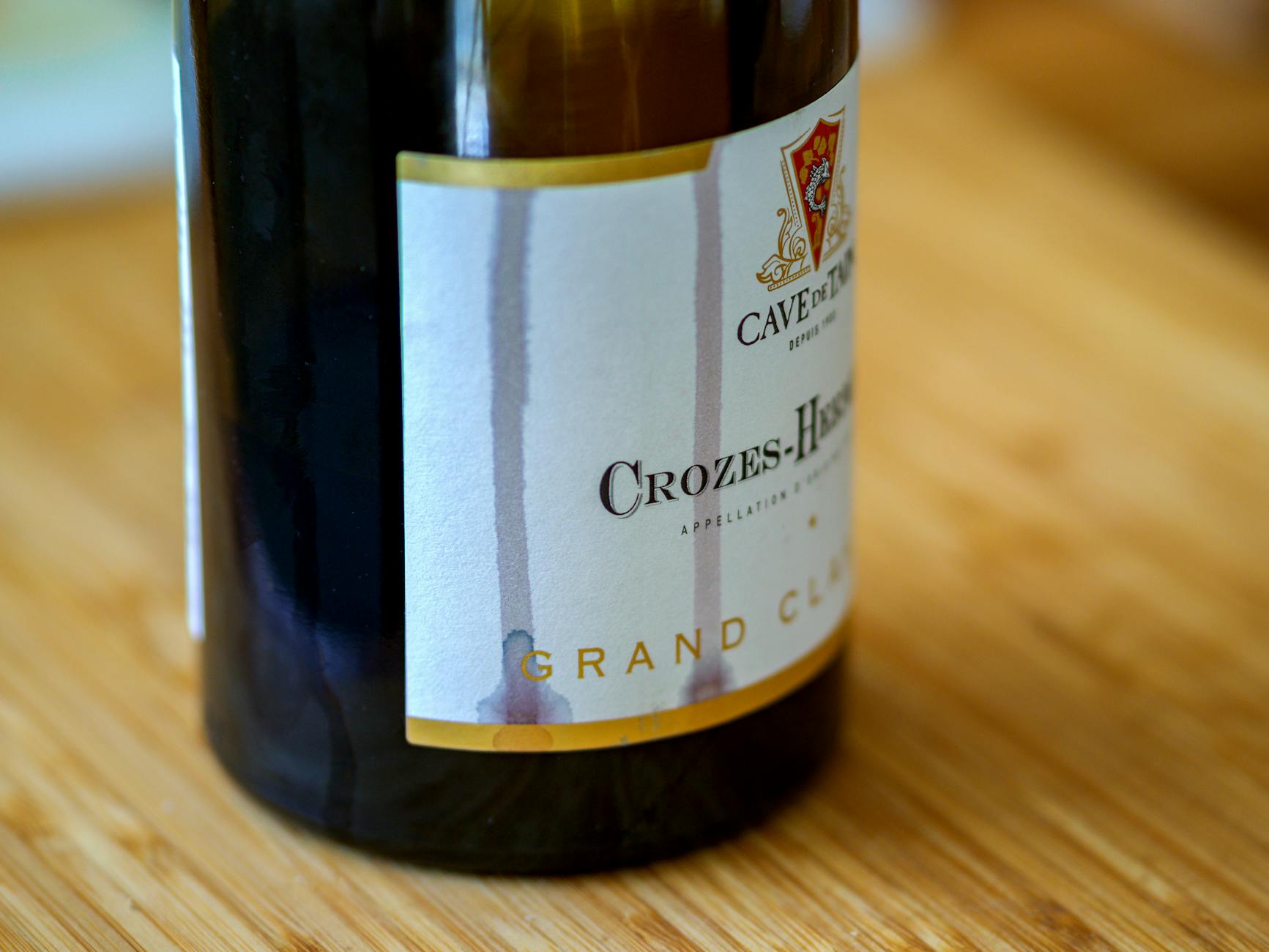 Zbliżenie butelki wina Crozes-Hermitage na drewnianym blacie