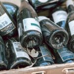 Puste butelki po winie i szampanie w skrzyni do recyklingu